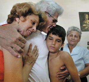 BACK HOME: Released Cuban dissident Manuel Vazquez Portal reunites with his son Gabriel, wife Yolanda, left, and sister Francisca in Havana on Thursday. ADALBERTO ROQUE/AFP-GETTY IMAGES